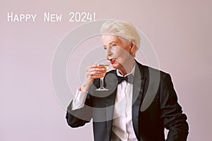 stylish mature senior woman in tuxedo with glass of sparkling wine celebrating