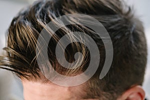 Stylish men`s hairstyle close-up. Hair brown