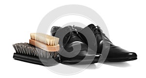 Stylish men`s shoes and cleaning brushes on white