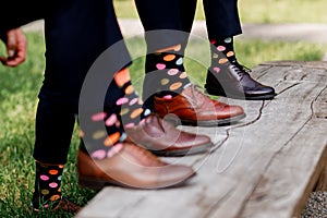 Stylish men`s socks. Stylish suitcase, men`s legs, multicolored socks and new shoes. Concept of style, fashion, beauty and