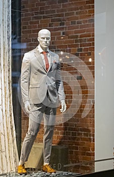 Stylish men`s suit on a mannequin in the shop window. Suit in a showcase of a luxury store