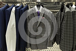 Stylish men`s suits in the store. Elegance and fashion. Close-up