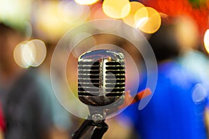 Stylish metal vocal microphone with blurry lights background