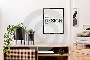 Stylish minimalistic living room interior with mock up poster frame, commode, plants in black pots and accessories. White walls.