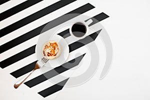 Minimalistic workspace with cup of coffee, bakery, isolated on striped black and white background. Flat lay style Top view.