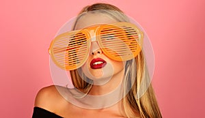 Stylish model in shutter shade sunglasses. Fashion portrait of woman in glamour striped glasses. Sexy beautiful blonde