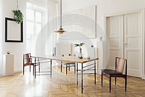 Stylish and modern dining room interior with design sharing table, chairs, gold pendant lamp, abstract paintings.