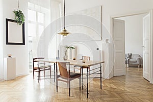 Stylish and modern dining room interior with design sharing table, chairs, gold pendant lamp, abstract paintings.