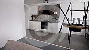 In a stylish modern kitchen is cleaning. The automatic robot vacuum cleaner moves along its trajectory. Elements of a