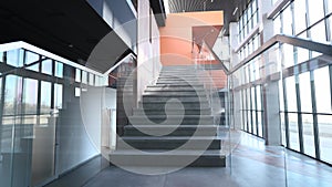 Stylish and modern office building lobby interior. Large panoramic windows and stairs with transparent railings