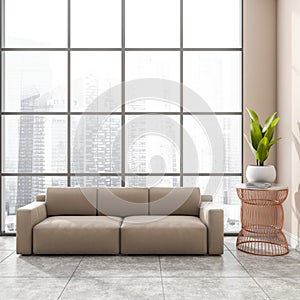 Stylish modern office room interior in skyscraper building with design beige leather couch, tile ceramic floor. Panoramic window.