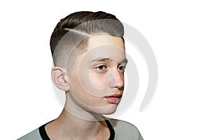 Stylish modern retro haircut side part with mid fade with parting of a schoolboy guy in a barbershop on an isolated white