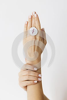 Stylish modern round ring on beautiful hands on white background. Unusual fused glass ring