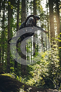 Stylish Mountain Bike Air with Sideways Trick Over Forest Trees