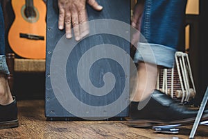 Stylish musician playing the Cajon drums.