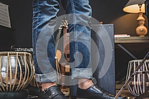 Stylish musician playing the Cajon drums.