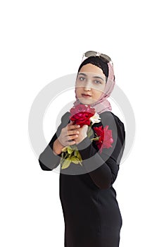 Stylish Muslim woman in traditional Islamic clothing holding flower bouquet. Portrait of beautiful middle-eastern girl in Hijab.