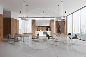 Stylish office interior with kitchen cabinet and eating tables, panoramic window