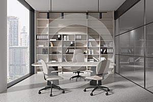 Stylish office interior with work desk and shelf with folders, panoramic window