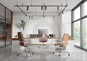 Stylish office interior with work desk and sideboard with panoramic window