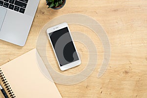 Stylish office table desk. Workspace with laptop, coffee cup, paper notebook, pen, succulent plant on wooden background. Minimal