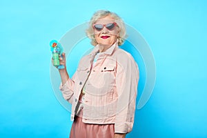 Stylish old lady with a toy in her hand looking at the camera