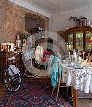 Stylish old vintage interior design. Old brick wall. Hardwood floor. Wooden furniture. Retro bicycle. Home decor.