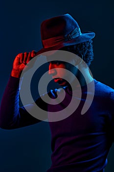 Stylish outlook man in hat on dark background