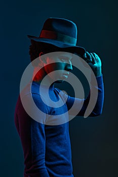 Stylish outlook man in hat on dark background