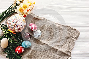 Stylish painted eggs and easter cake on rustic wooden background