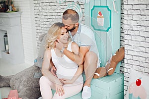 Stylish parents sitting on stairs, embracing and kissing.