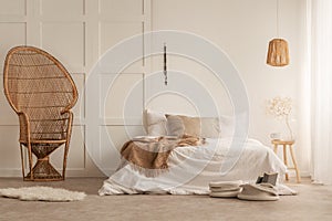 Stylish peacock chair in elegant bedroom, photo with copy space on the empty wall