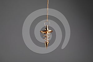 Stylish pendulum on grey background. Hypnotherapy session