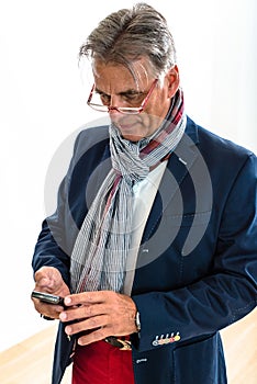 Stylish pensioner checking his mobile phone