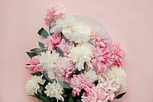 Stylish peonies bouquet flat lay. Pink and white peonies on pastel pink paper. Hello spring. Happy mothers day, floral greeting