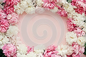 Stylish peonies flat lay. Pink and white peonies frame on pastel pink paper with space for text. Happy mothers day greeting card