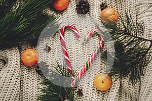 Stylish peppermint candy cane in heart and pine cones tangerine