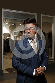 Stylish portrait of a young businessman in a tie and glasses of interesting appearance, vertical view