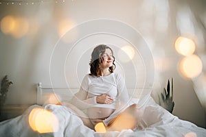 Stylish pregnant mom hugging belly with love and care, waiting for baby. Motherhood concept, magic time. Happy pregnant woman in