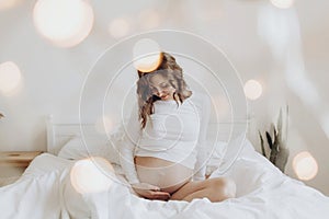 Stylish pregnant mom hugging belly with love and care, waiting for baby. Motherhood concept, magic time. Happy pregnant woman in