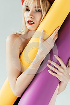 Stylish pretty woman holding colorful paper rolls