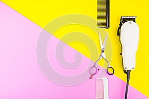Stylish Professional Barber Scissors and White electric clippers on yellow and pink background. Hairdresser salon concept,