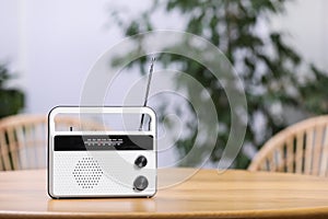 Stylish radio receiver on wooden table indoors, space for text