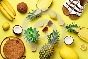 Stylish rattan bag, coconut, birkenstocks, succulent, sunglasses and yellow fruits on sunny background. Banner. Top view