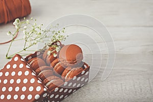 Stylish red dots box with tasty macarons on wooden background. Minimalist concept of style and french chic, copy space