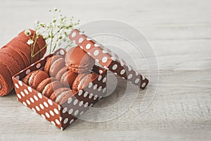 Stylish red dots box with tasty macarons on wooden background. Minimalist concept of style and french chic, copy space