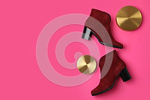 Stylish red female boots and decor on pink background. Space for text