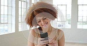 Stylish redhead woman reading a romantic text message on her phone. One trendy and stylish female smiling and thinking