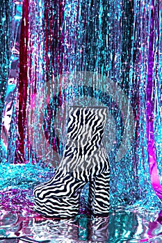 Stylish Retro disco platform zebra boots on party tinsel background. New year`s clubbing mood. Merry christmas. Holiday. Fashion