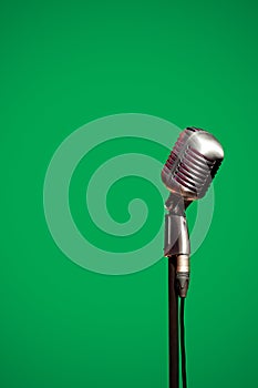 Stylish retro microphone on a green background